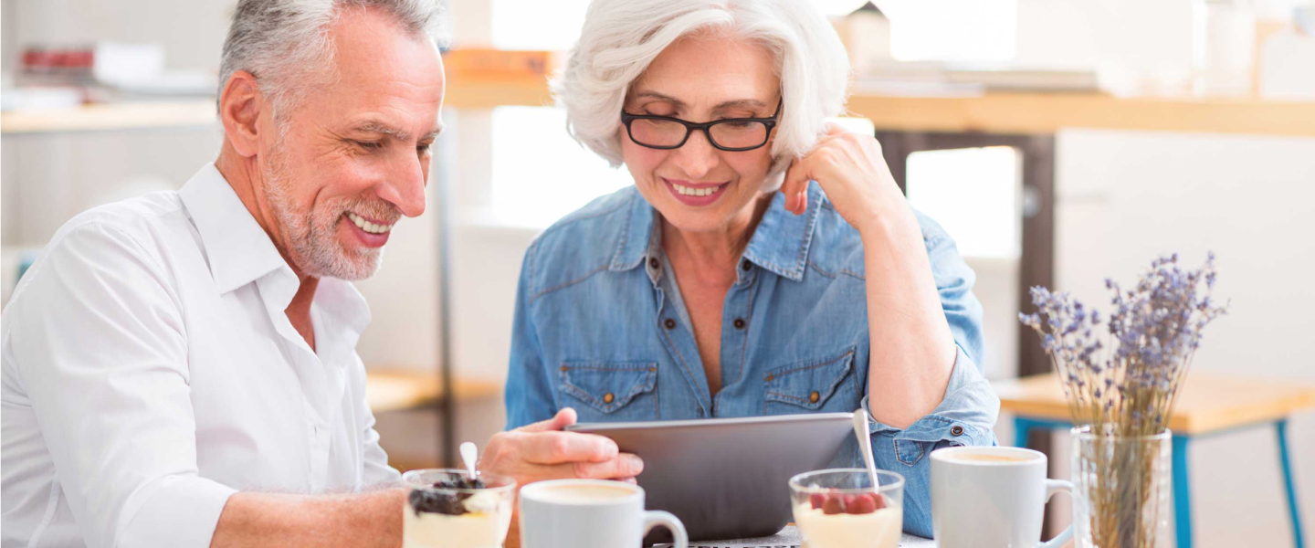 Man and woman looking at a laptop while sitting on the couch, learning about LUMA’s Customer Battery Energy Sharing Program